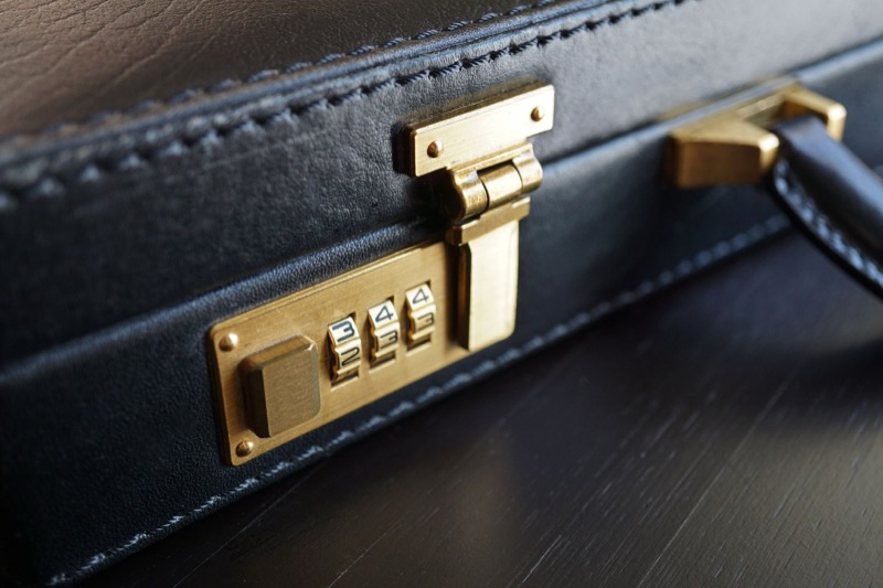 A brass combination lock on a black leather briefcase