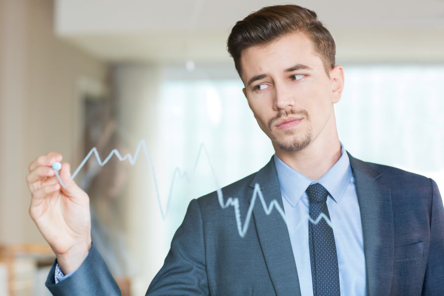 A trader at a multi-screen desk watching live market charts, representing Aster's Pro mode order book
